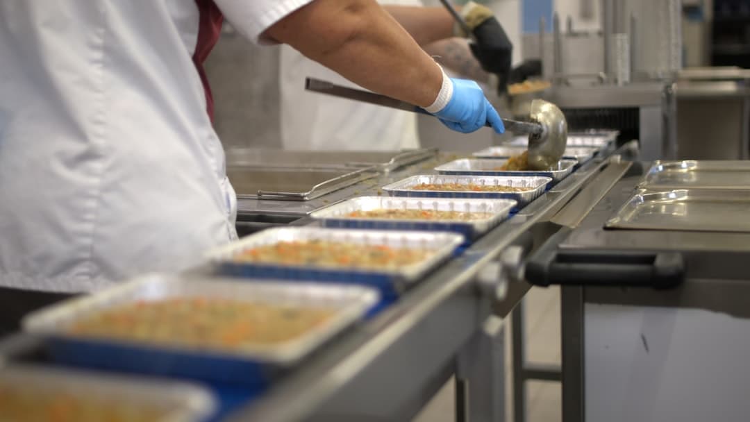 Restaurant staff staging family meals and party trays for large pickup orders
