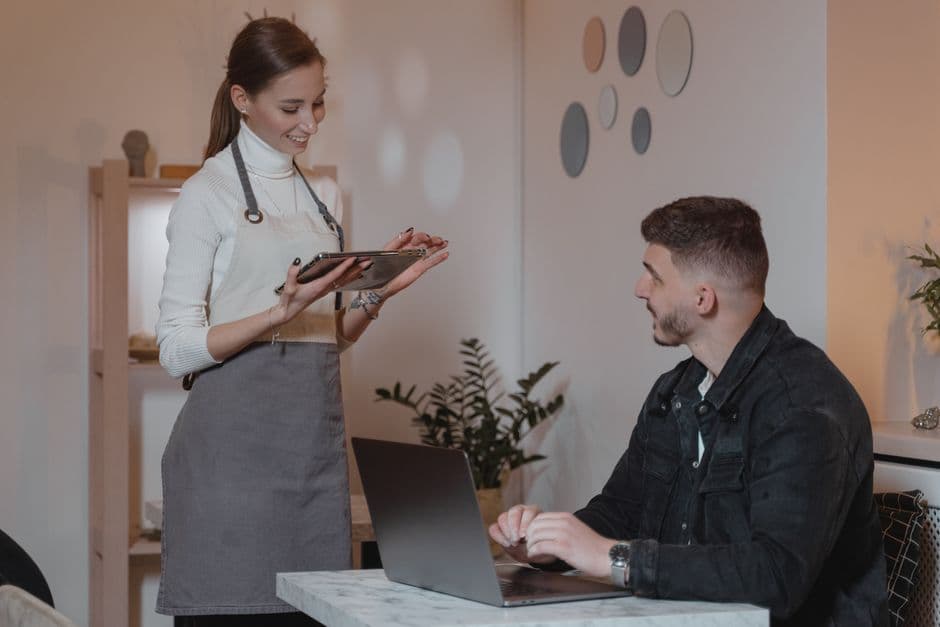 Restaurant owner and manager reviewing weekly digital menu analytics before service