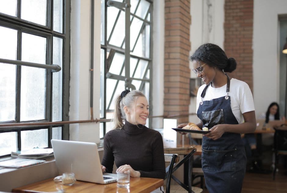Restaurant manager reviewing menu performance and add-on results on a laptop