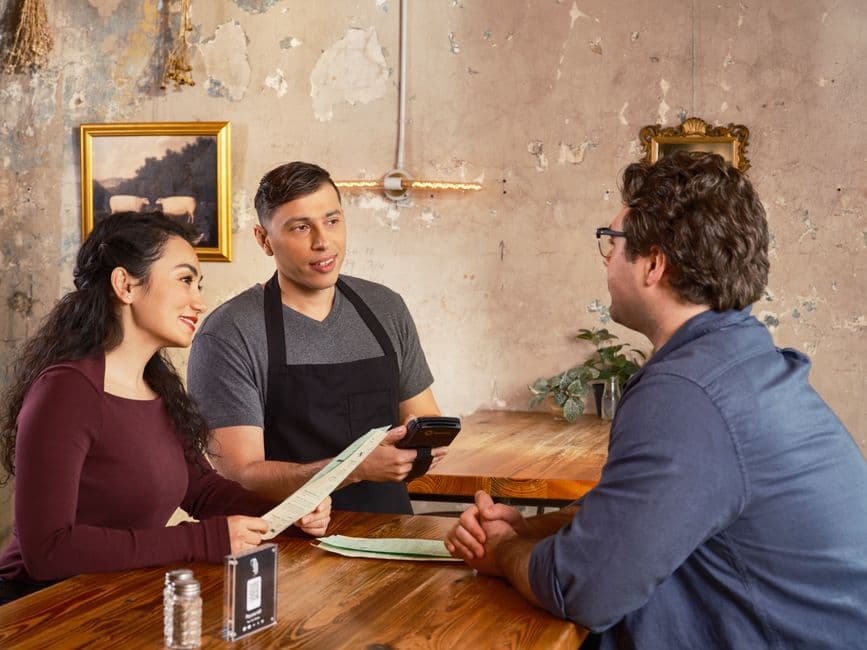 Restaurant manager auditing a mobile ordering flow with a checklist