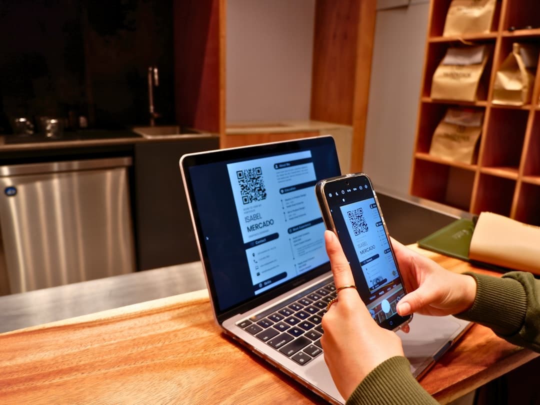 Restaurant manager reviewing an online ordering system on a tablet near a pickup counter with a QR code menu sign