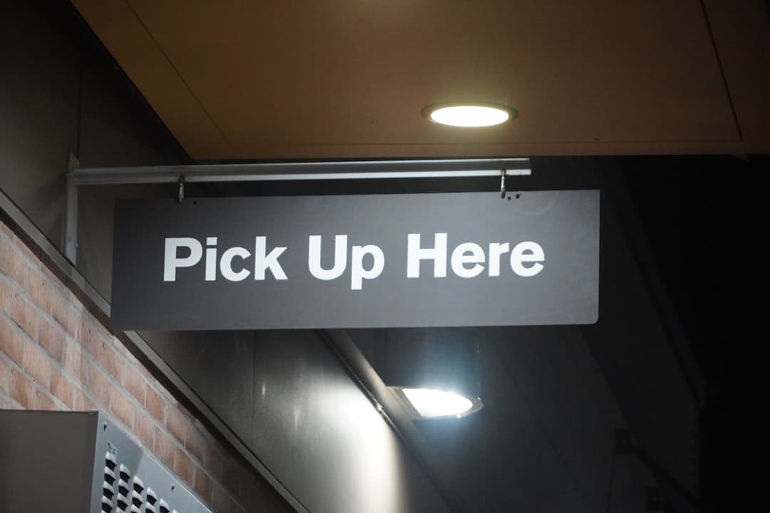 Restaurant pickup shelf with clear labels and directional signs for takeout guests